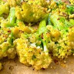 roasted cauliflower with parmesan cheese on a baking sheet