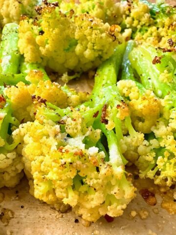 roasted cauliflower with parmesan cheese on a baking sheet