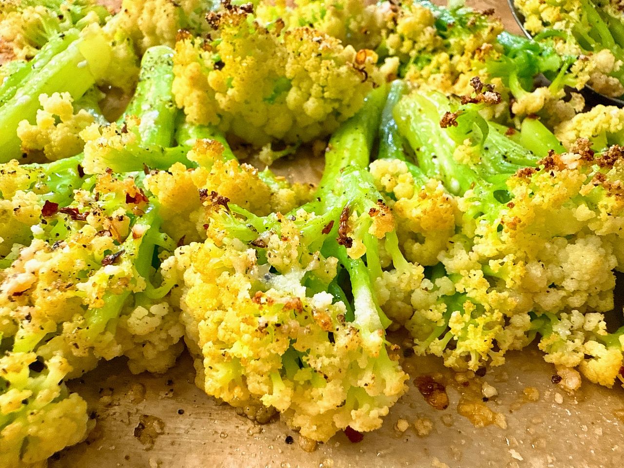 roasted cauliflower with parmesan cheese on a baking sheet