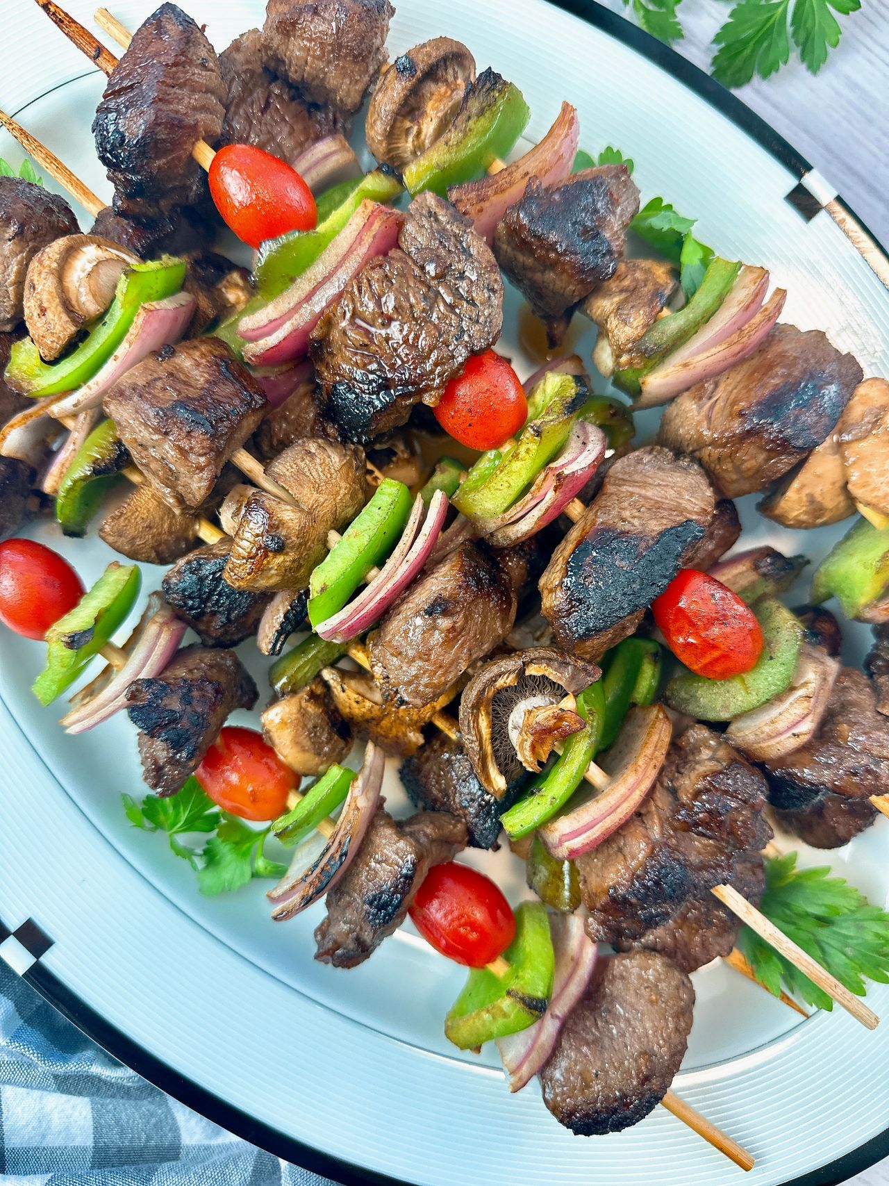 beef and vegetable kebabs on a white serving plate