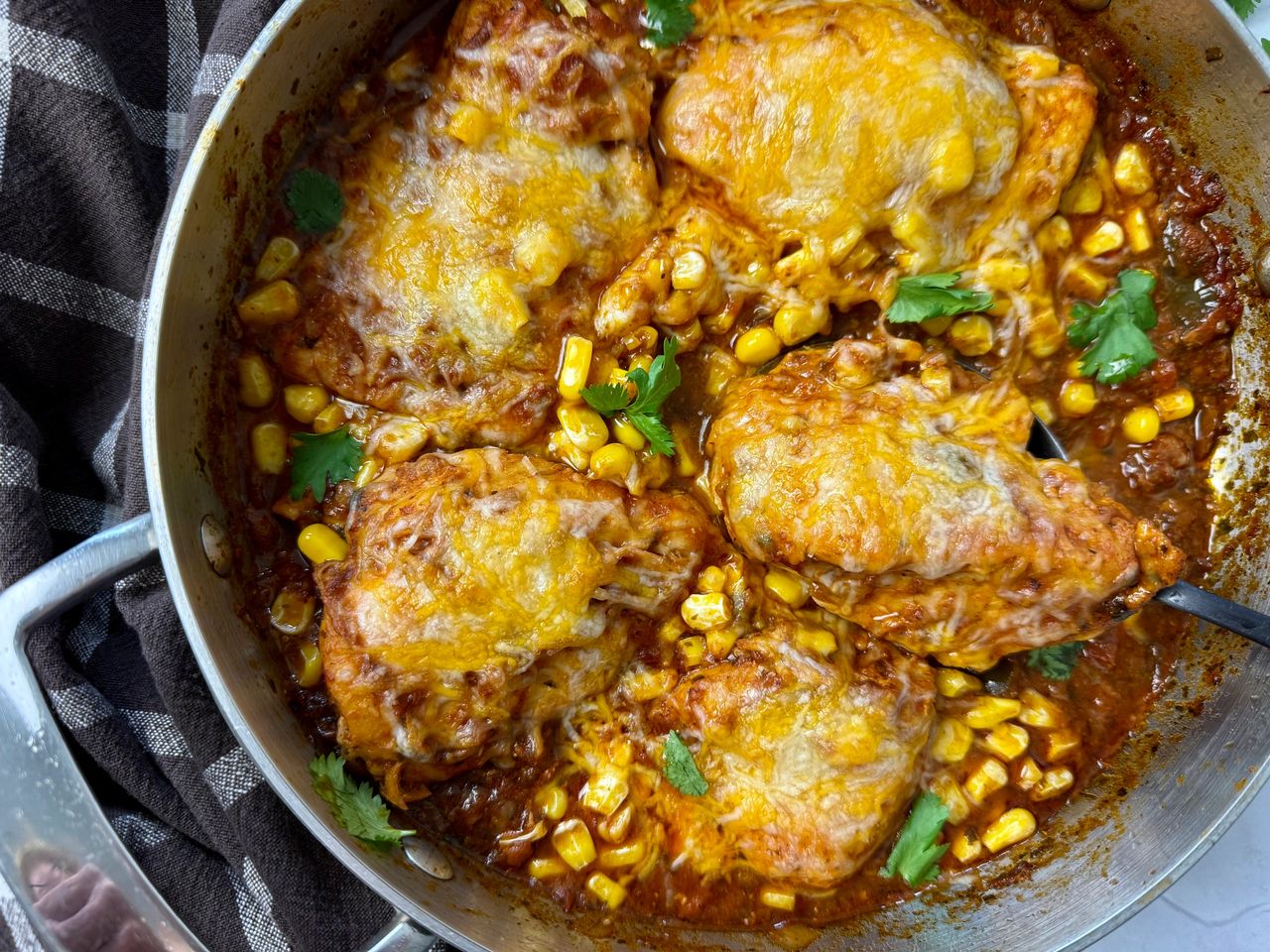 Easy Salsa Chicken salsa chicken with cheese in a silver pan with a black spoon