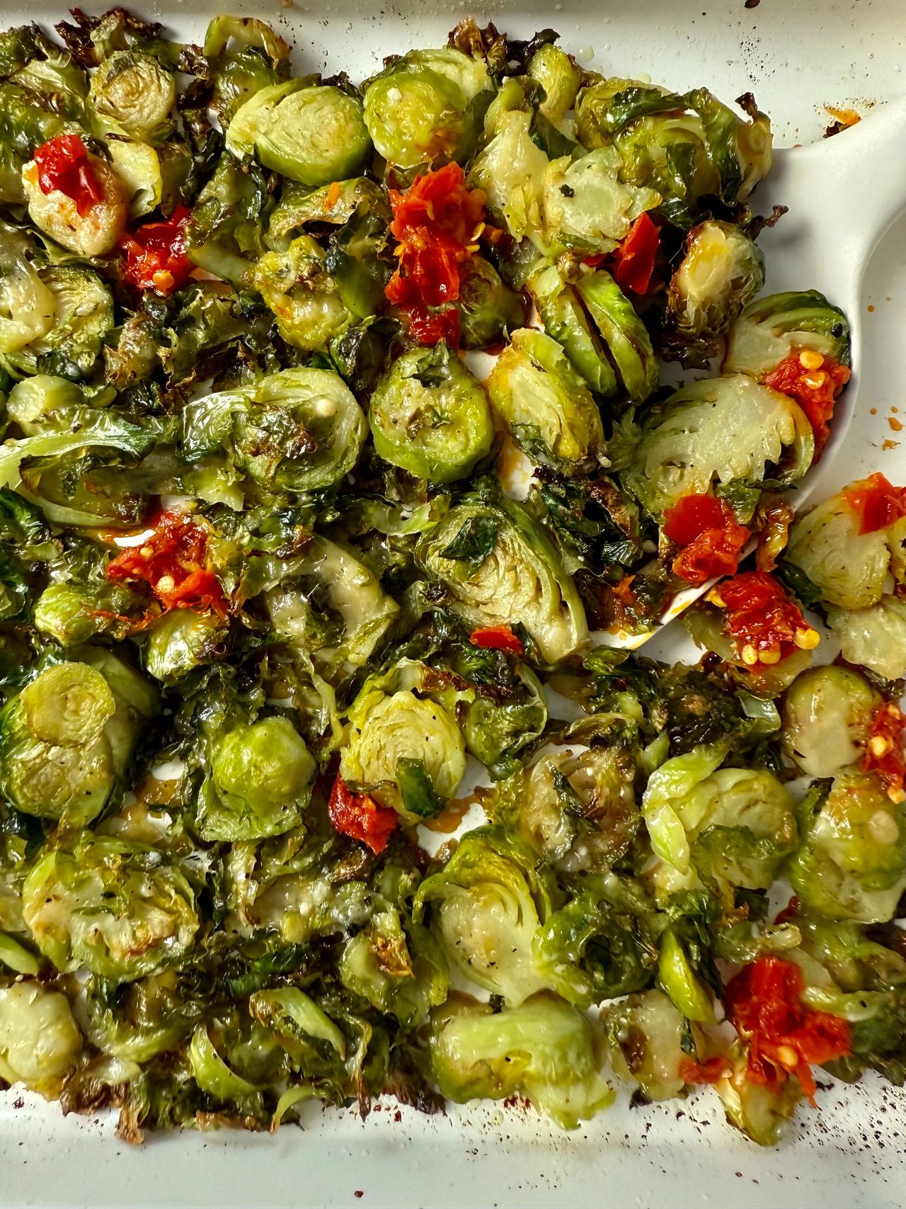 Shaved Brussels Sprouts with Calabrian Peppers on a white baking pan
