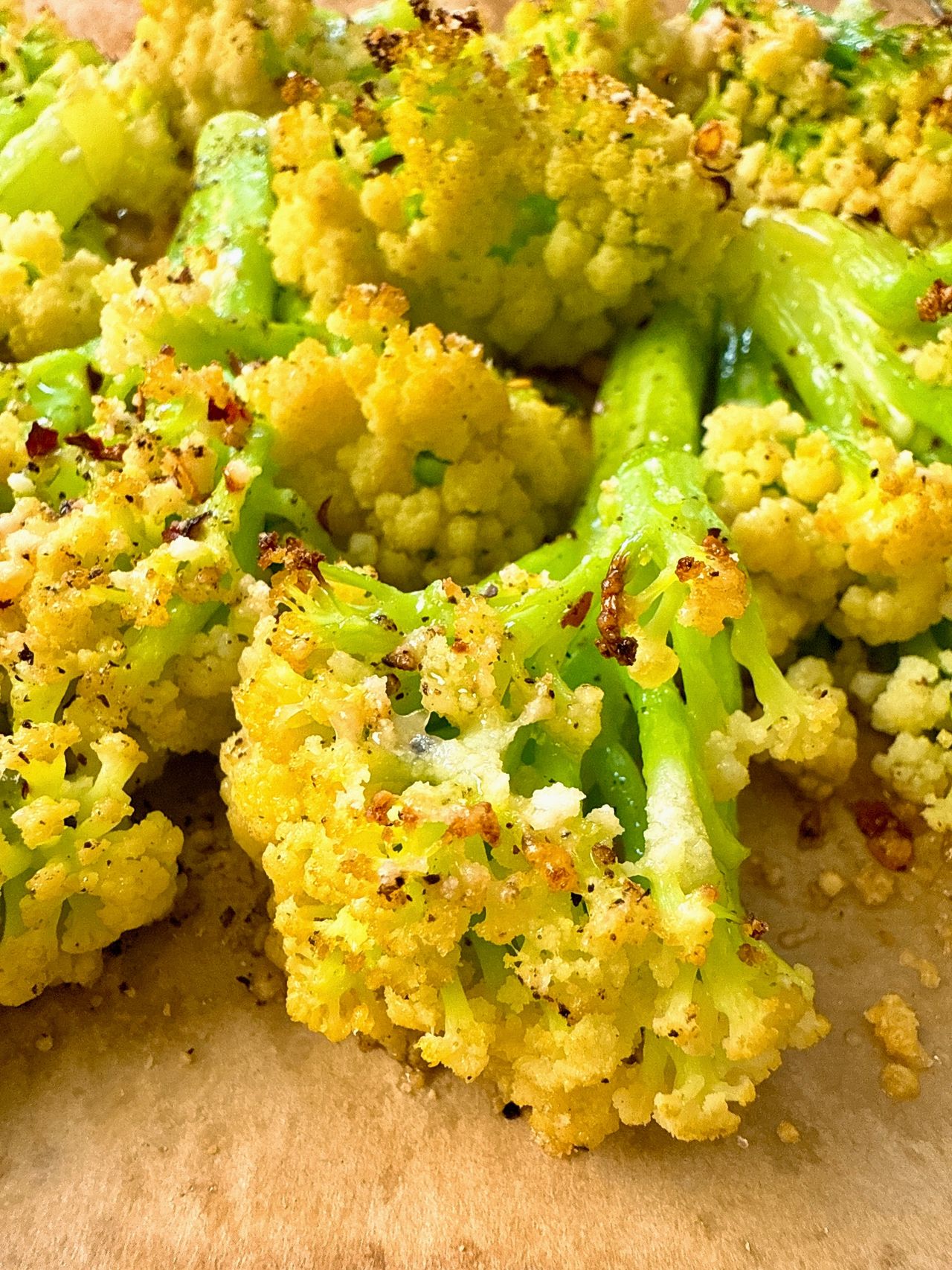 roasted cauliflower with parmesan cheese on a baking sheet