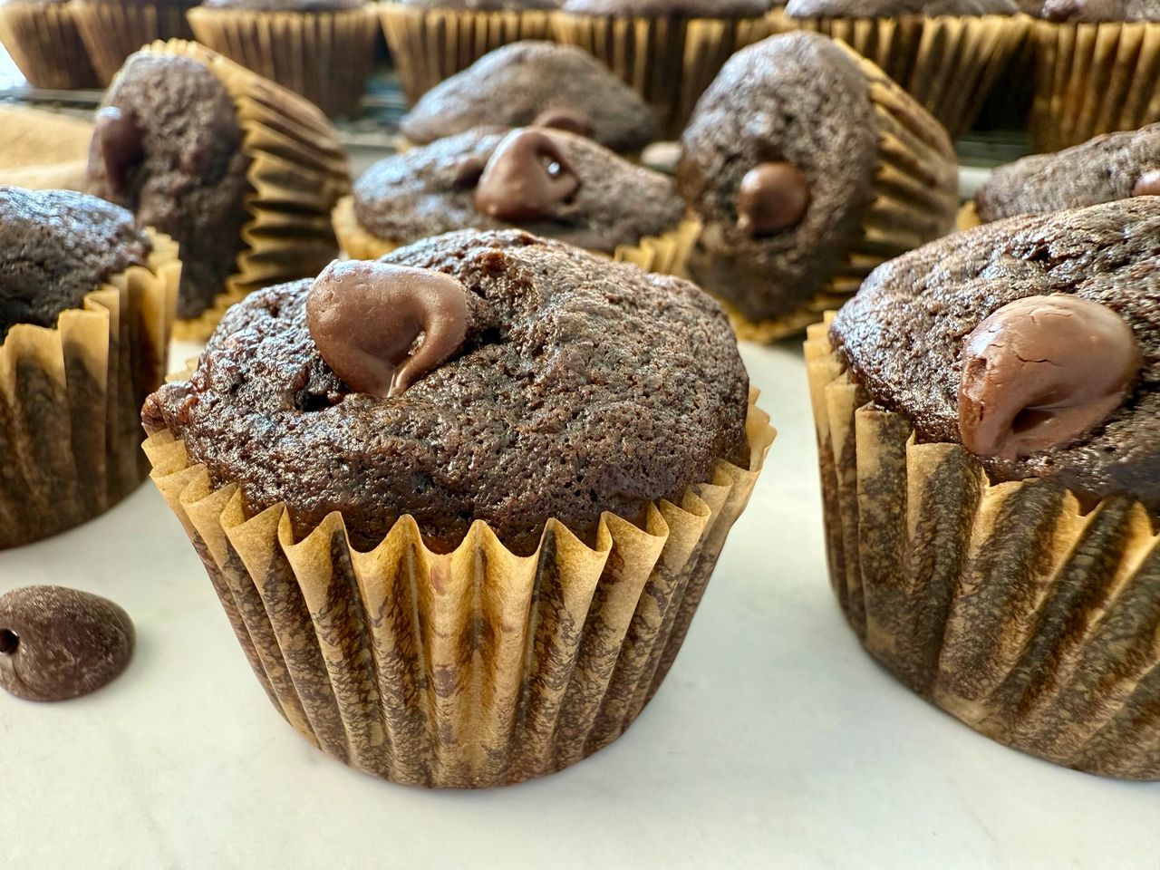 Double Chocolate Banana Muffins mini chocolate banana muffins on a white surface