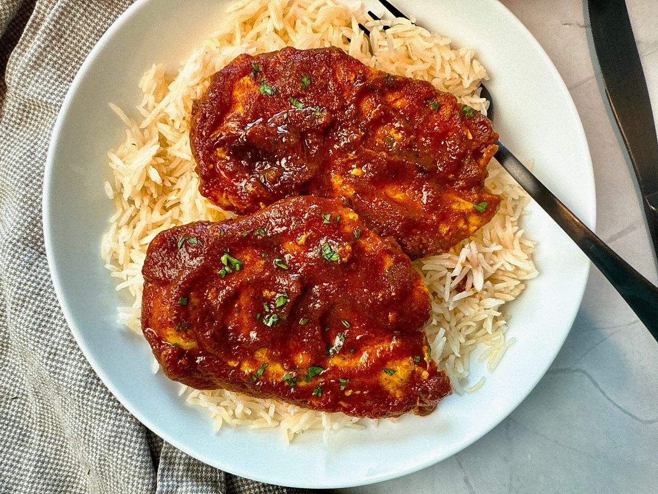 chicken with enchilada sauce over rice on a white plate