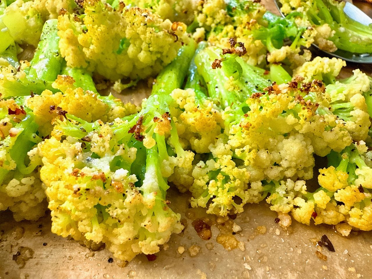 roasted cauliflower with parmesan cheese on a baking sheet