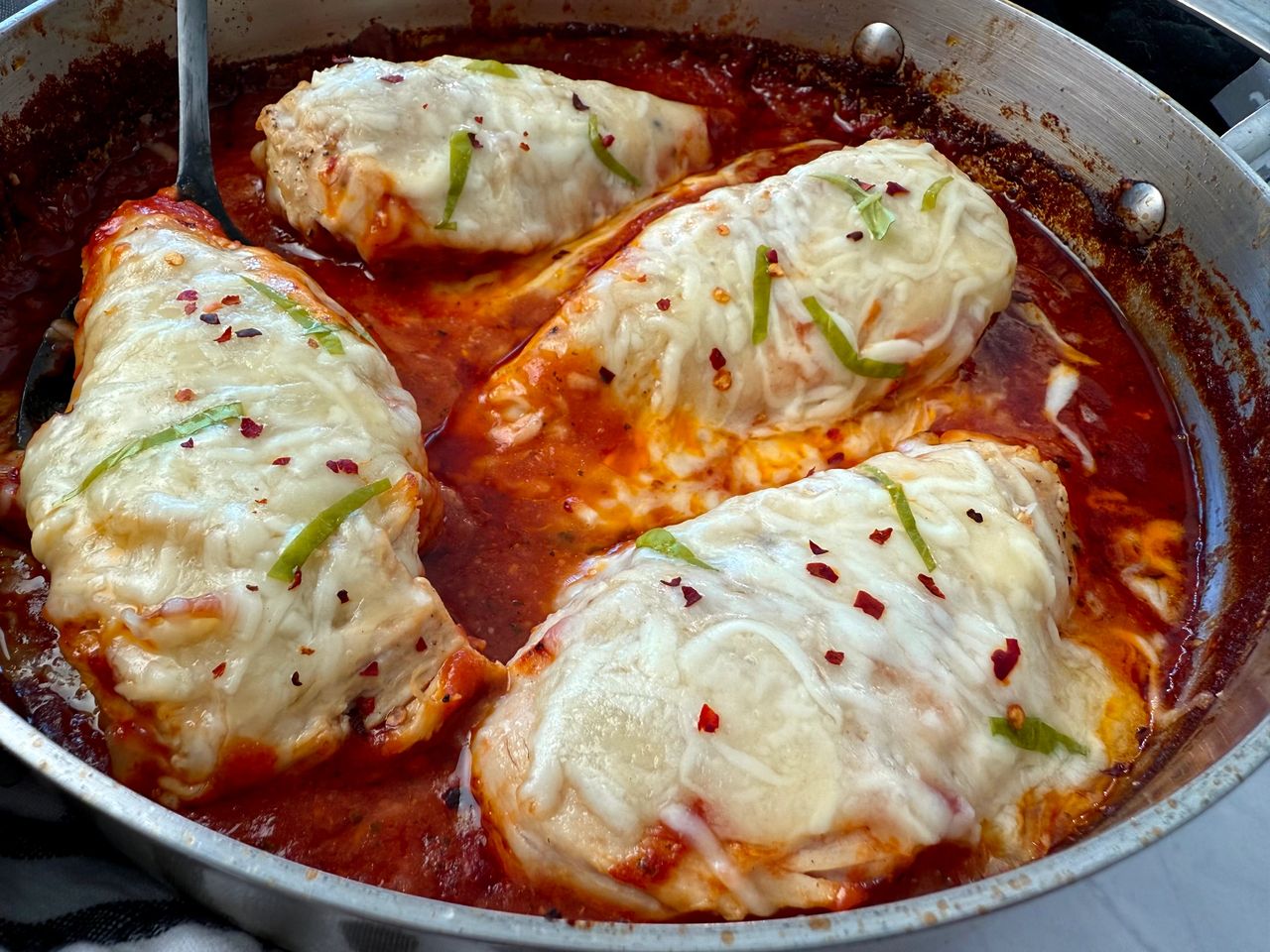 chicken with marinara sauce and cheese in a deep skillet