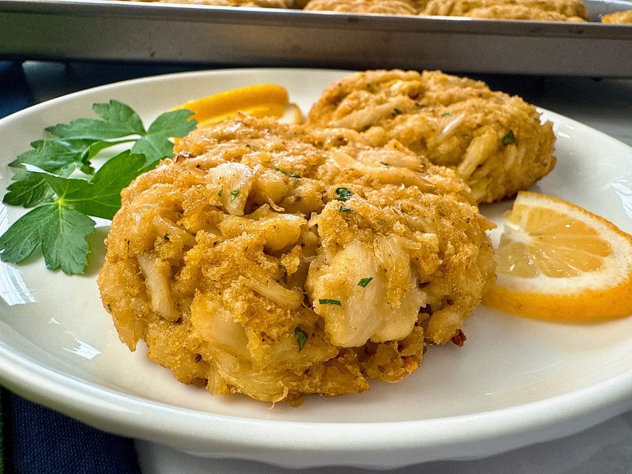 crab cakes and lemon slices on a white plate