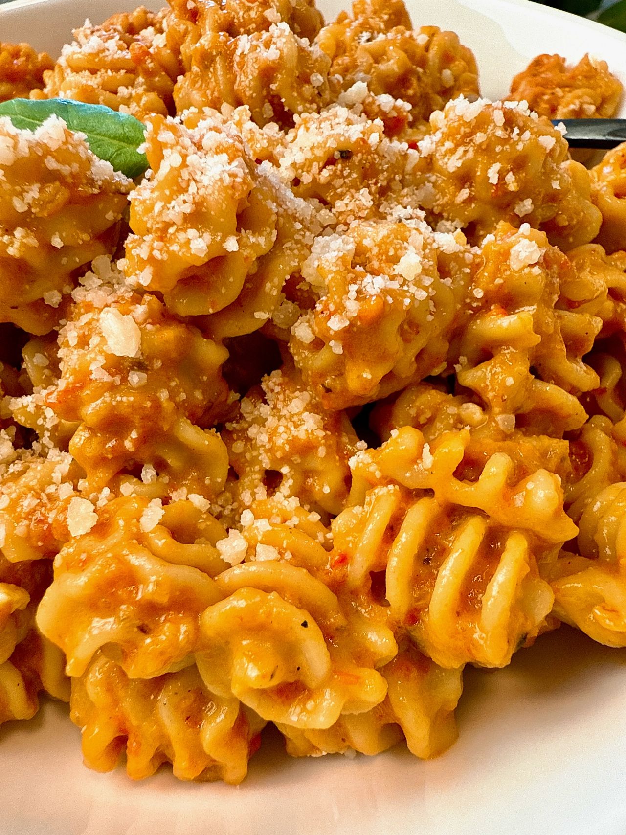 radiatori pasta with roasted red pepper sauce in a white bowl