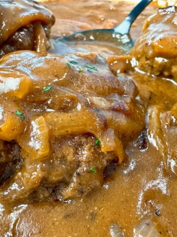 hamburger steaks and gravy with a black spoon