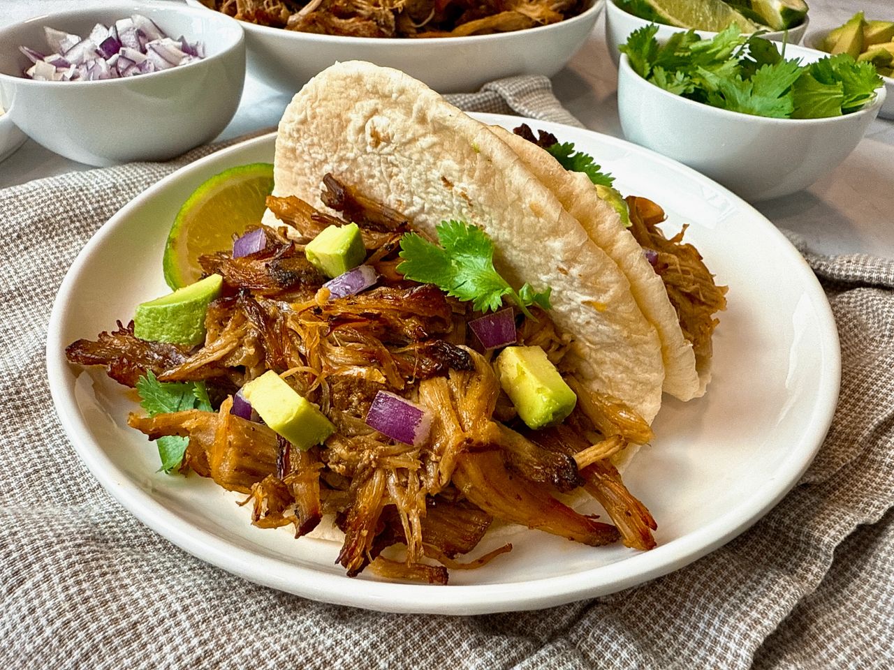 pork carnitas with avocado on a white plate