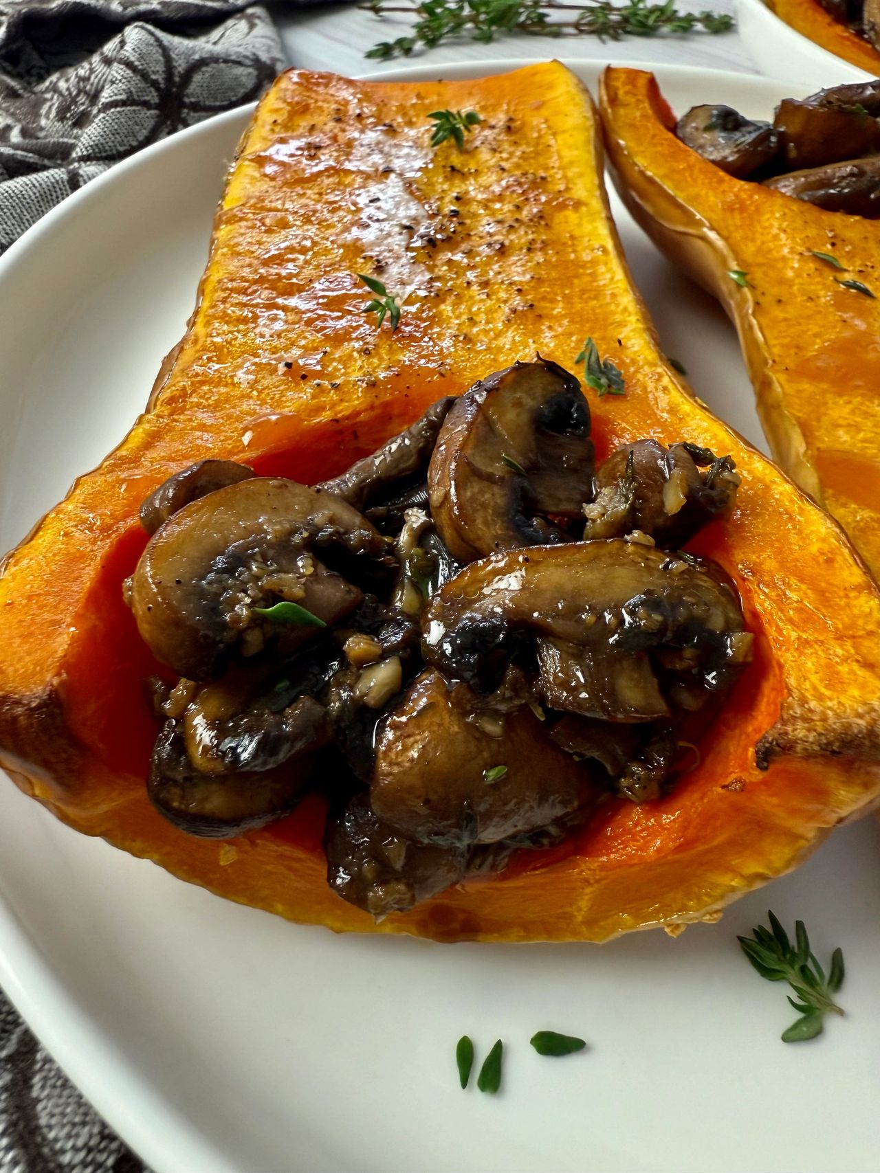 butternut squash stuffed with mushrooms on a white plate