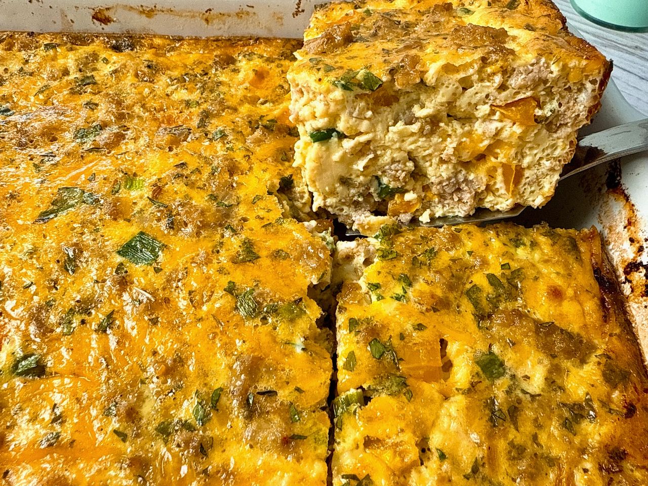 Breakfast Casserole on a spatula in a white baking dish