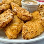 baked chicken fingers and honey mustard dip on a white plate