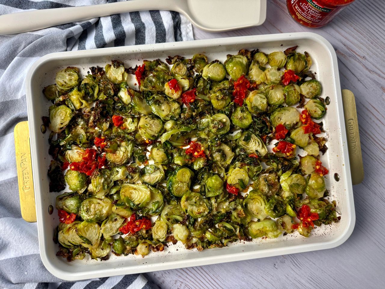 Shaved Brussels Sprouts with Calabrian Peppers on a white baking pan