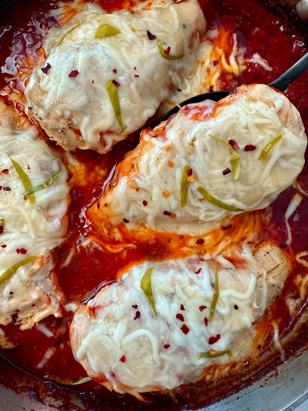 chicken with marinara sauce and cheese in a deep skillet