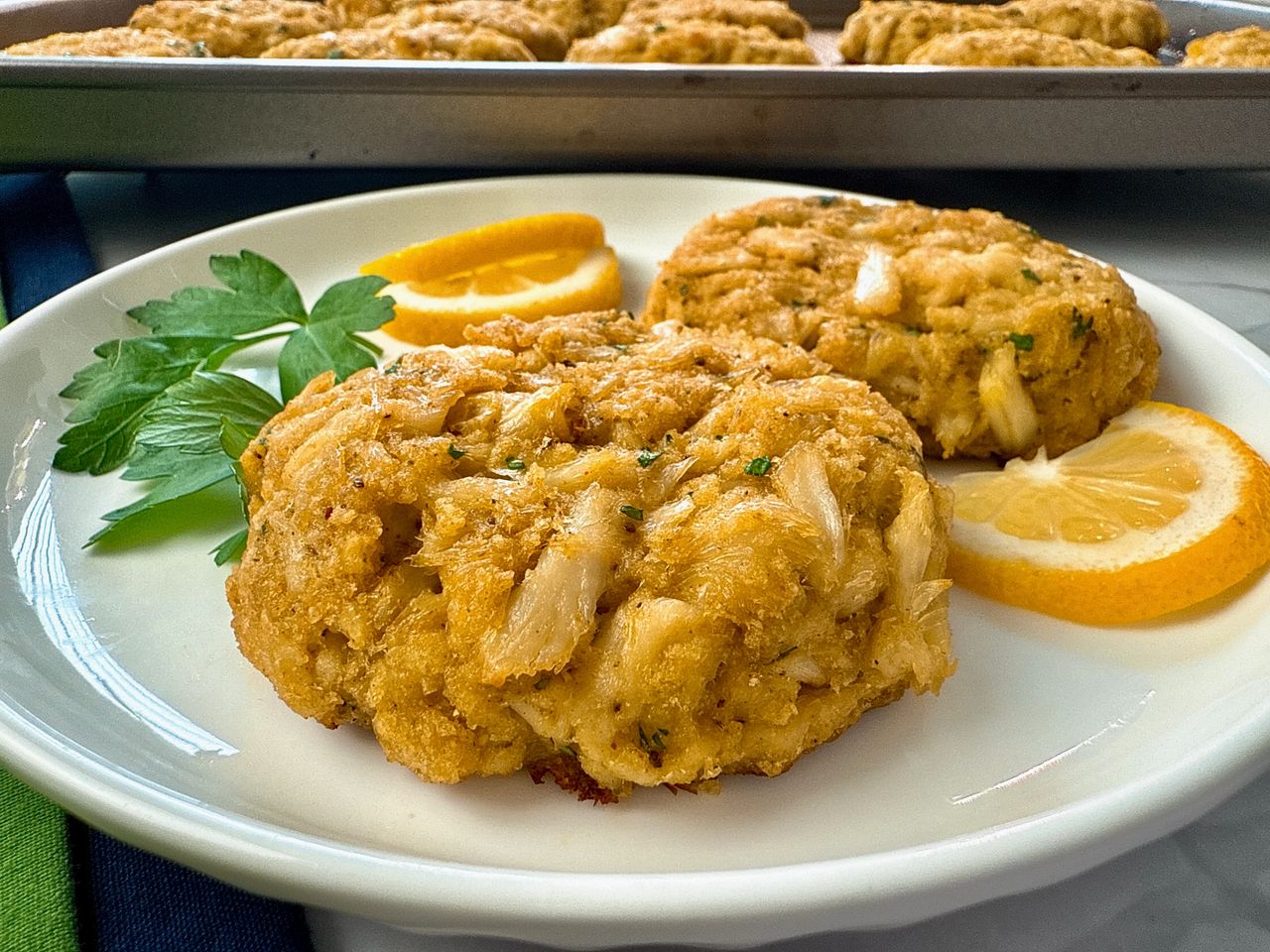 crab cakes and lemon slices on a white plate