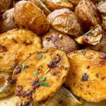 roasted potatoes and onion on a parchment paper lined baking sheet