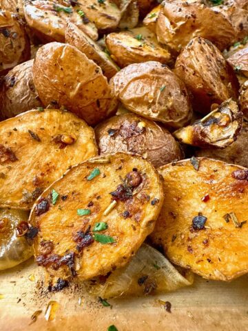 roasted potatoes and onion on a parchment paper lined baking sheet