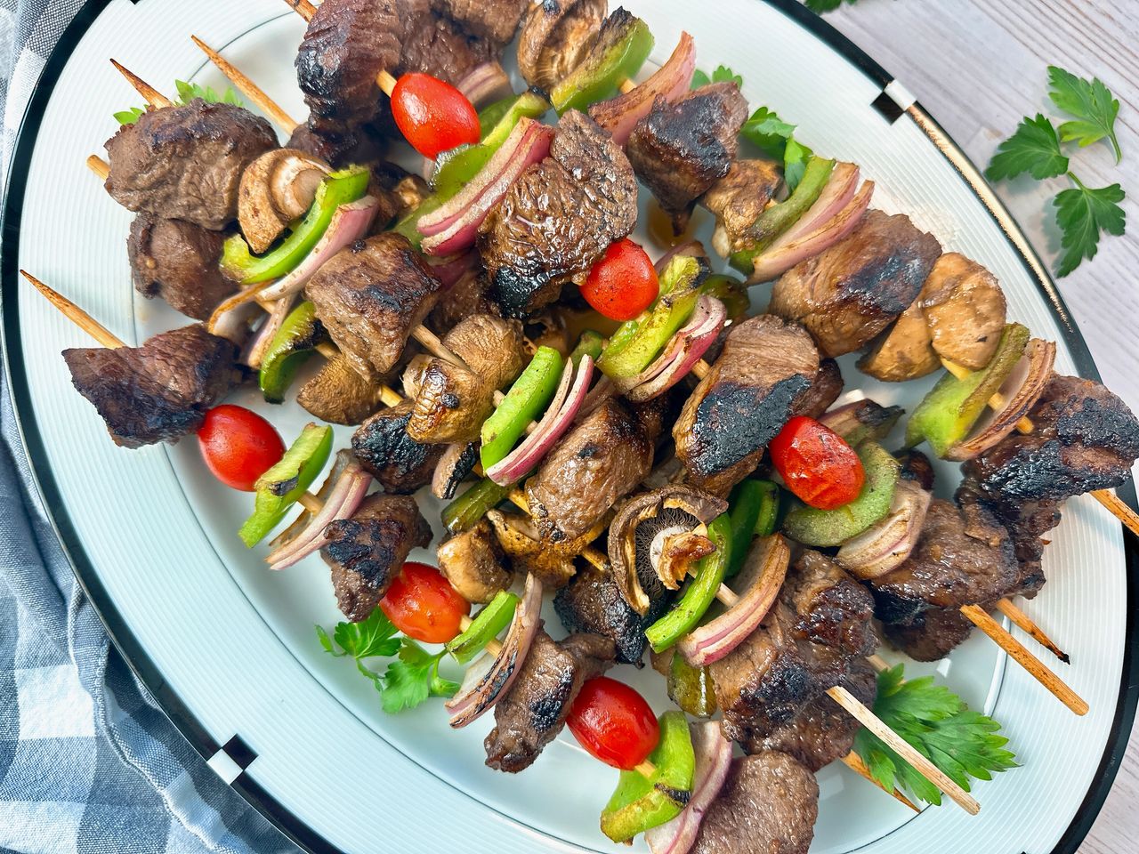 beef and vegetable kebabs on a white serving plate