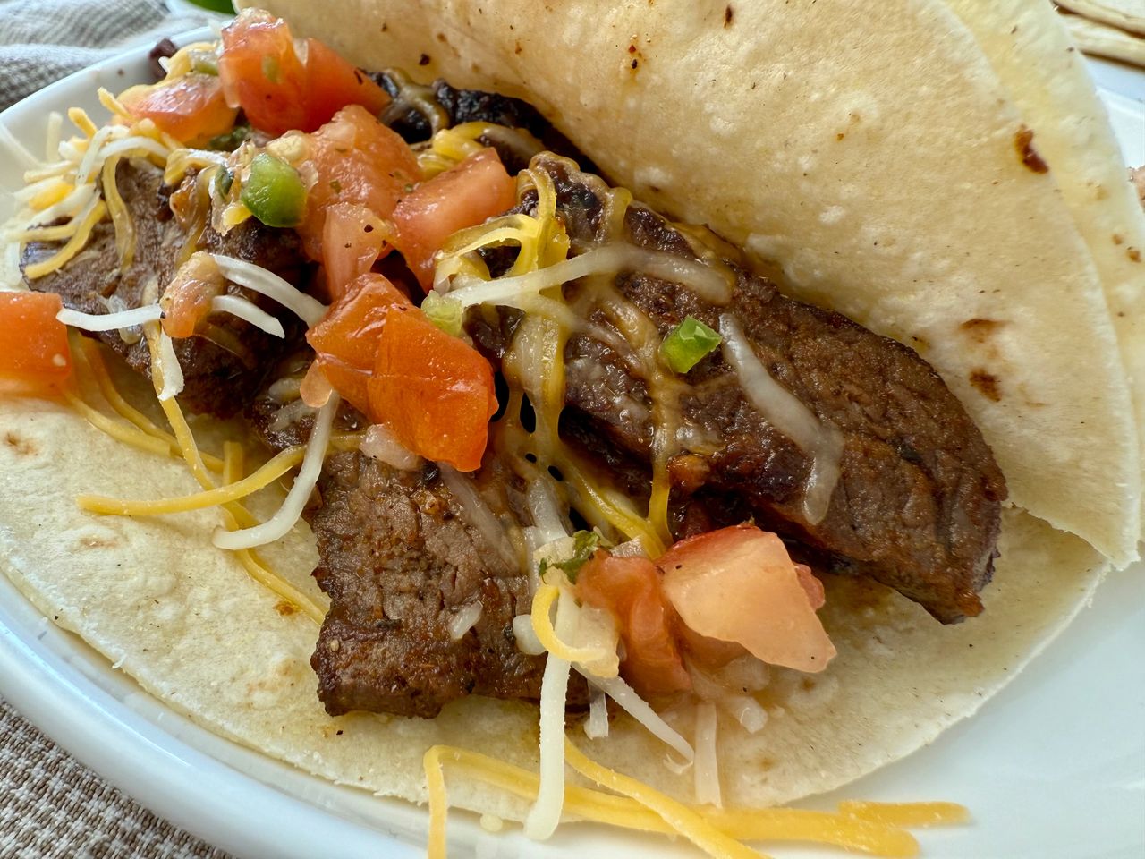 steak street tacos on a white plate with lime garnish
