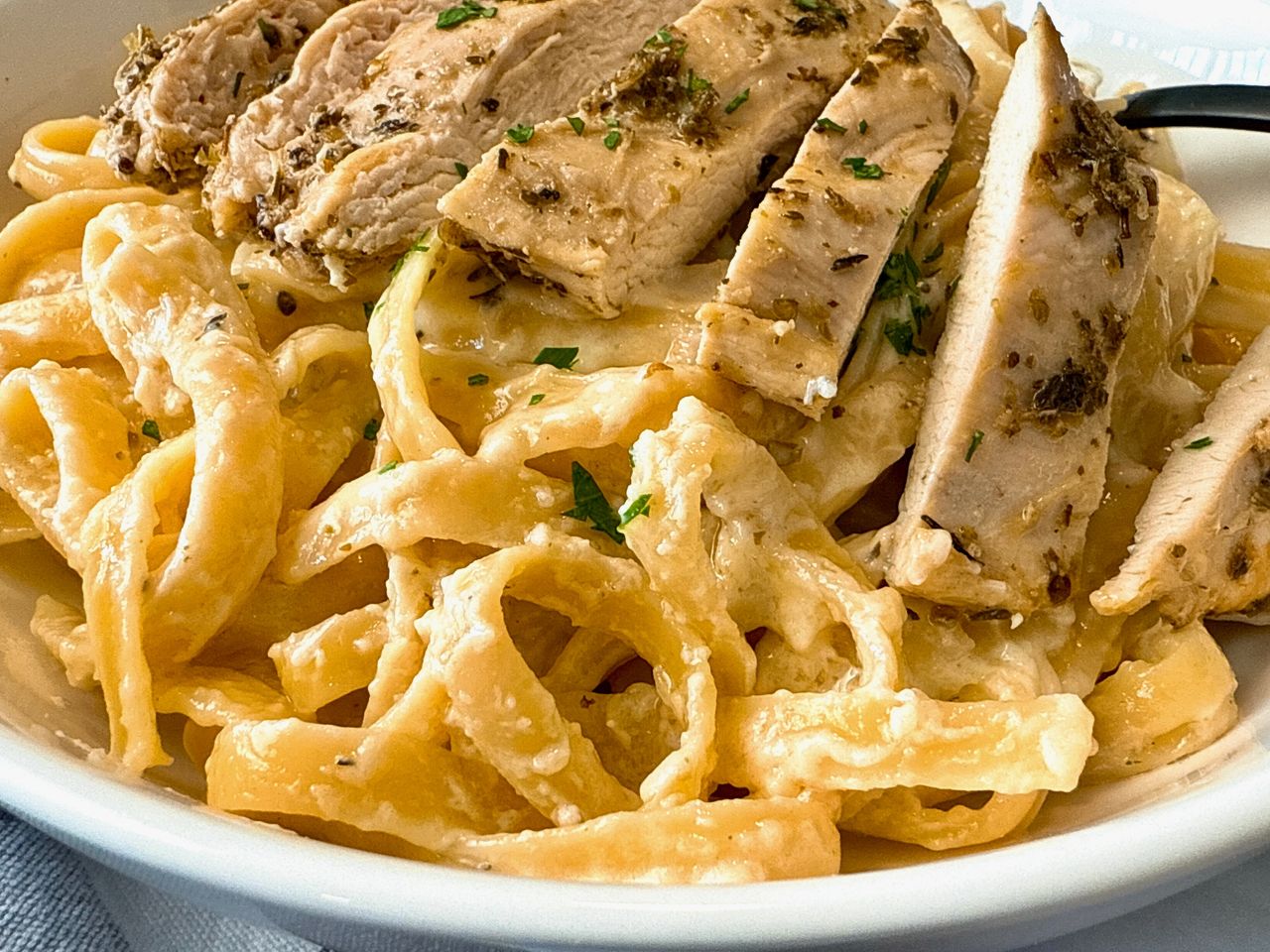 chicken alfredo in a white bowl