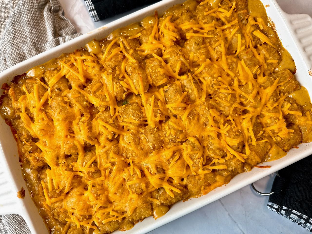 tater tot casserole in a white baking dish 