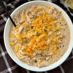 white chicken chili in a white bowl on a brown kitchen towel