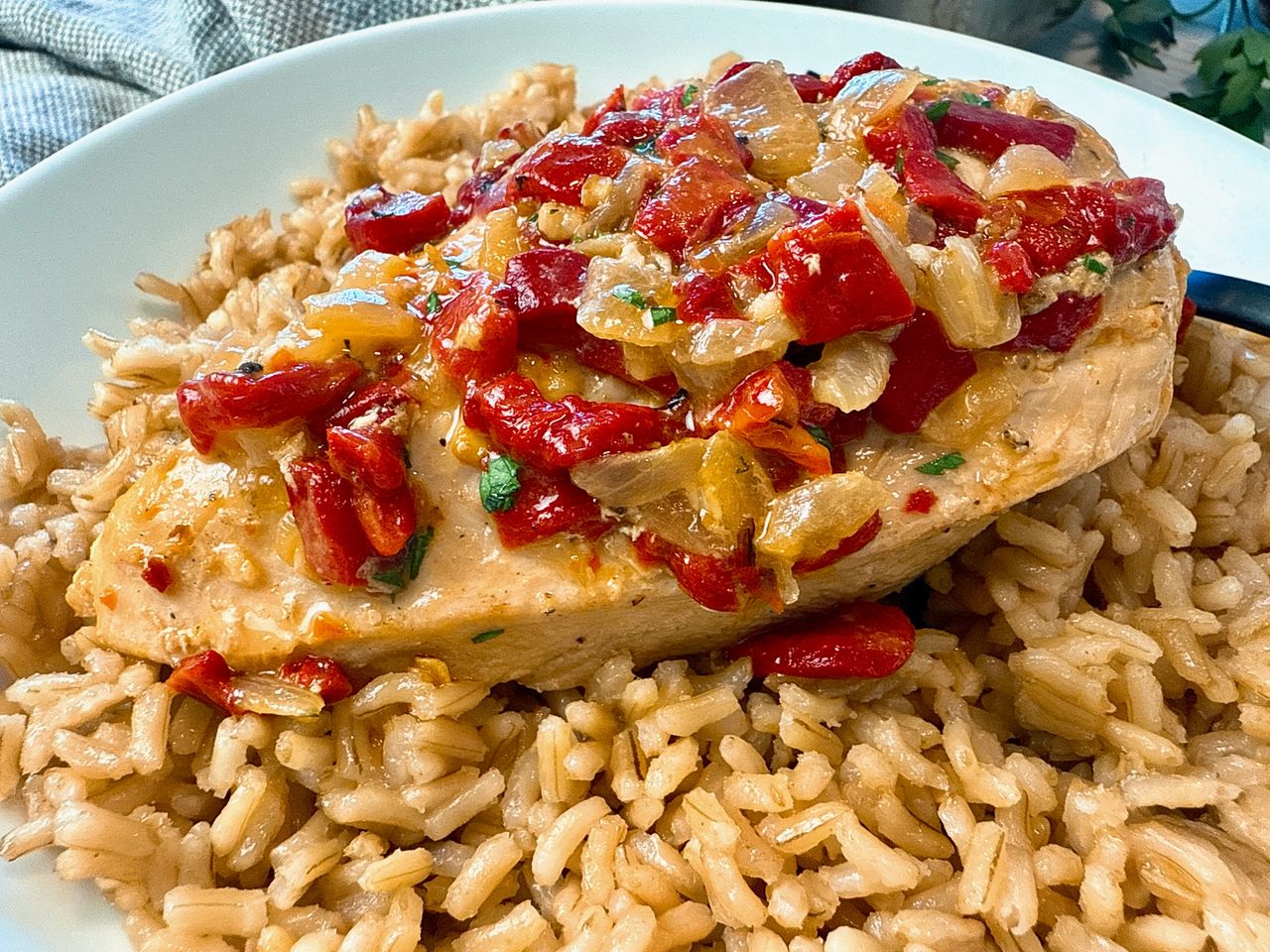 Roasted Red Pepper Chicken chicken breast with roasted red peppers over rice on a white plate