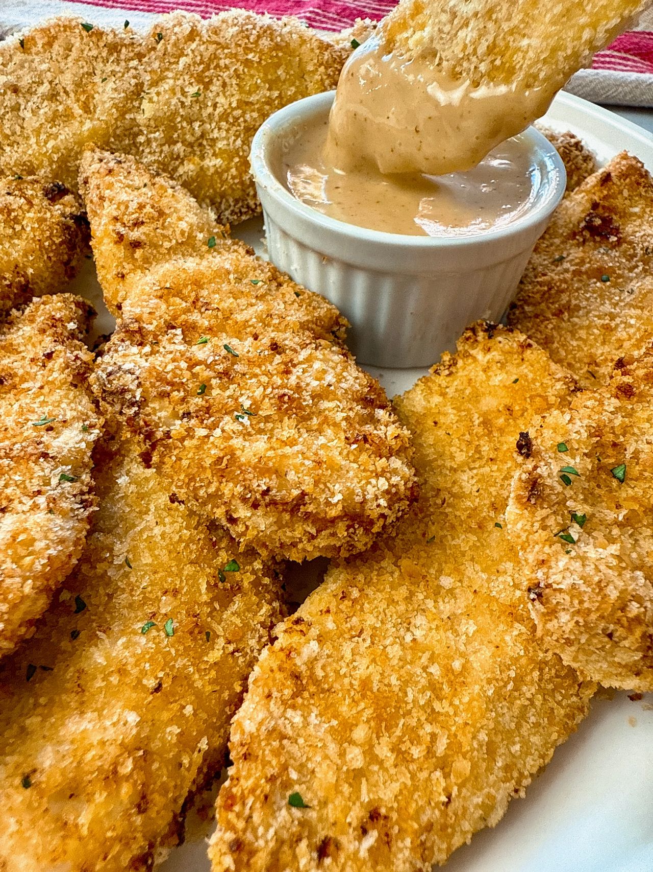 baked chicken fingers and honey mustard dip on a white plate