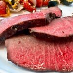 sirloin tip roast on a white plate with vegetables