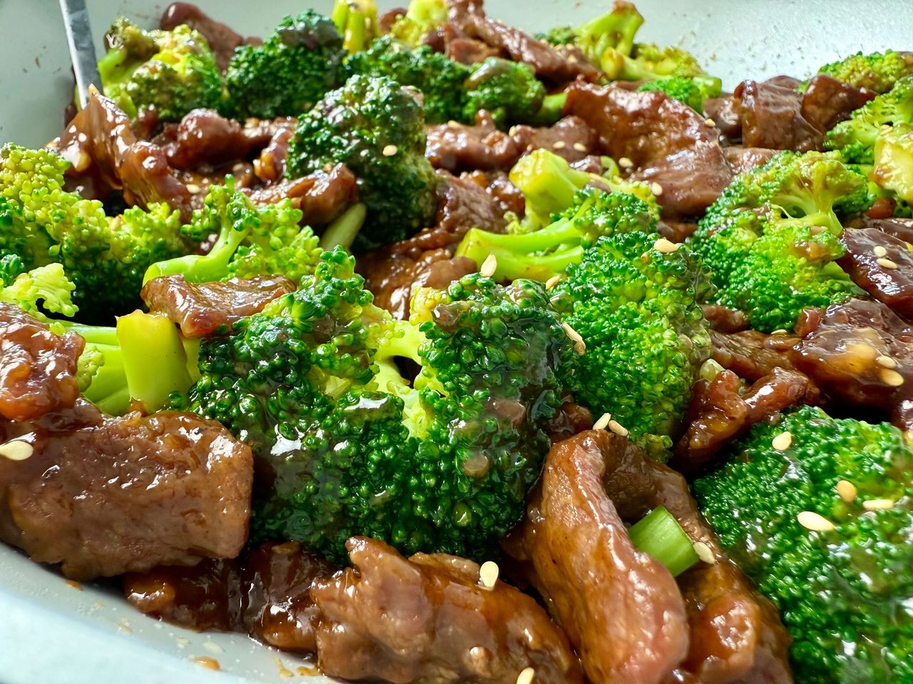 beef and broccoli in a white skillet
