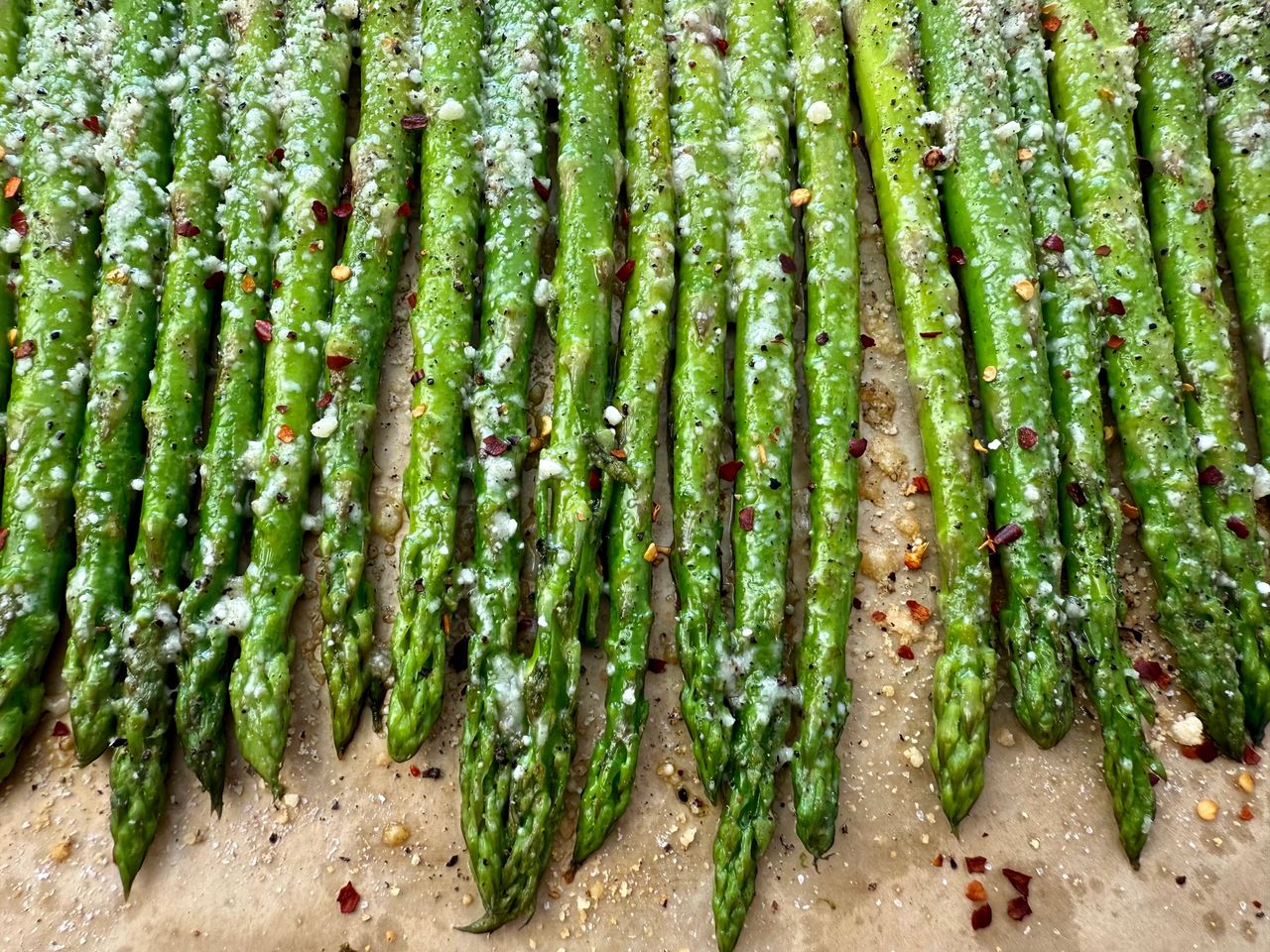 roasted asparagus on a sheet pan lined with parchment paper