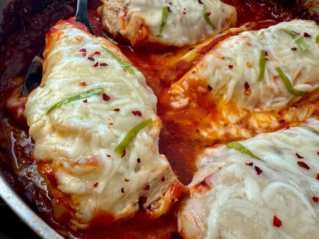 chicken with marinara sauce and cheese in a deep skillet