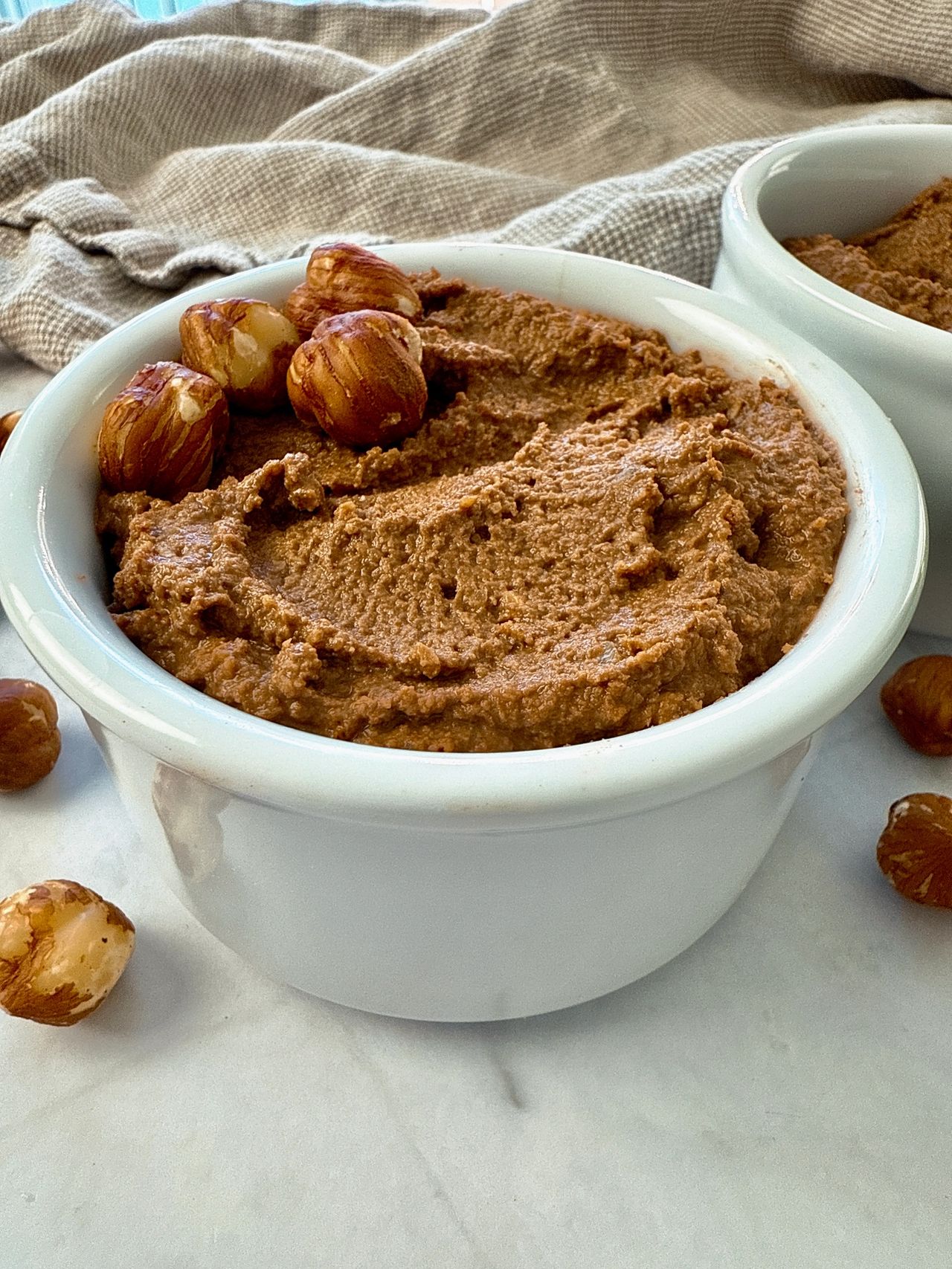 hazelnut spread in a white ramekin with a butter knife