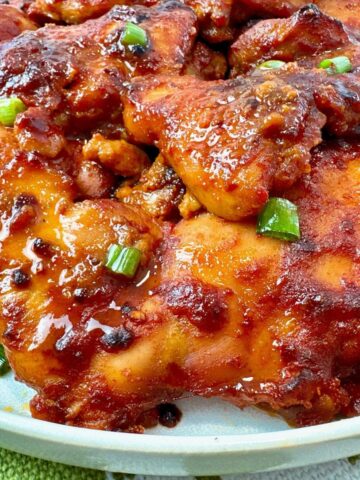 gochujang chicken thighs on a white plate