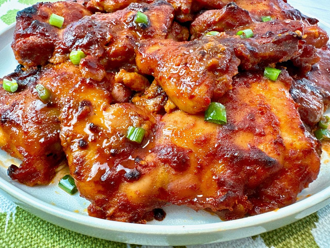 gochujang chicken thighs on a white plate