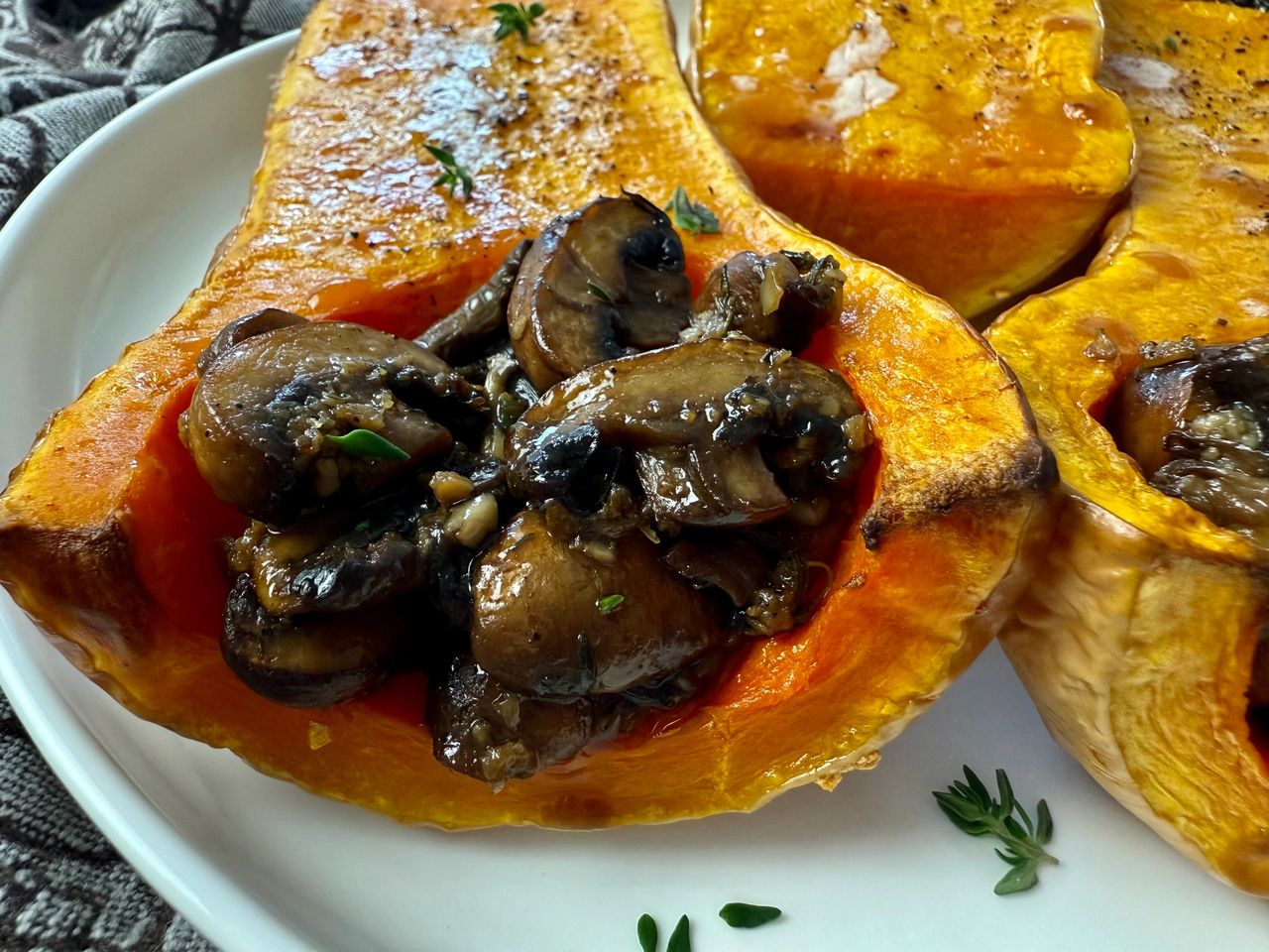 butternut squash stuffed with mushrooms on a white plate