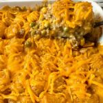 tater tot casserole in a white baking dish and on a spoon