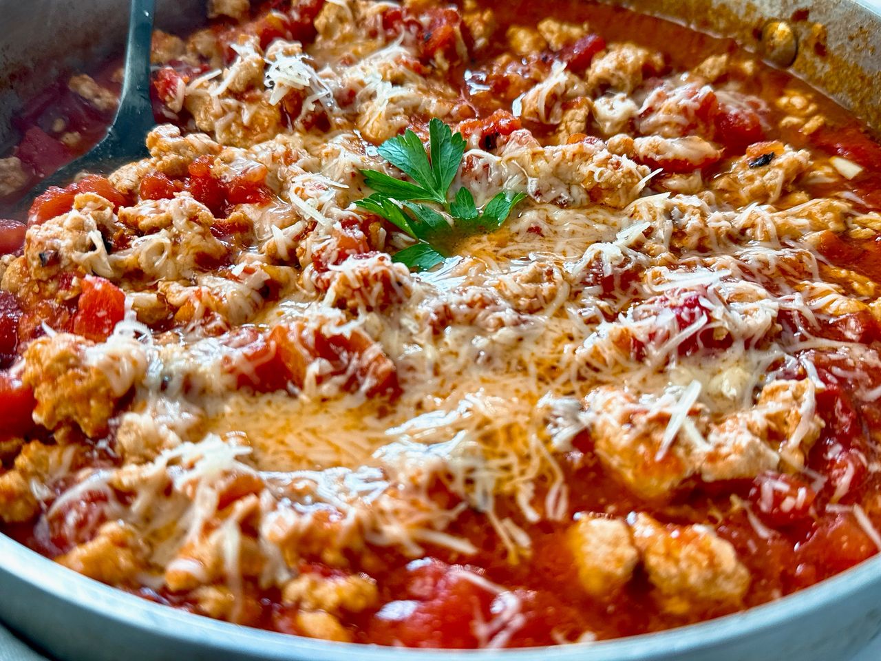 ground chicken arrabbiata with cheese in a silver pan