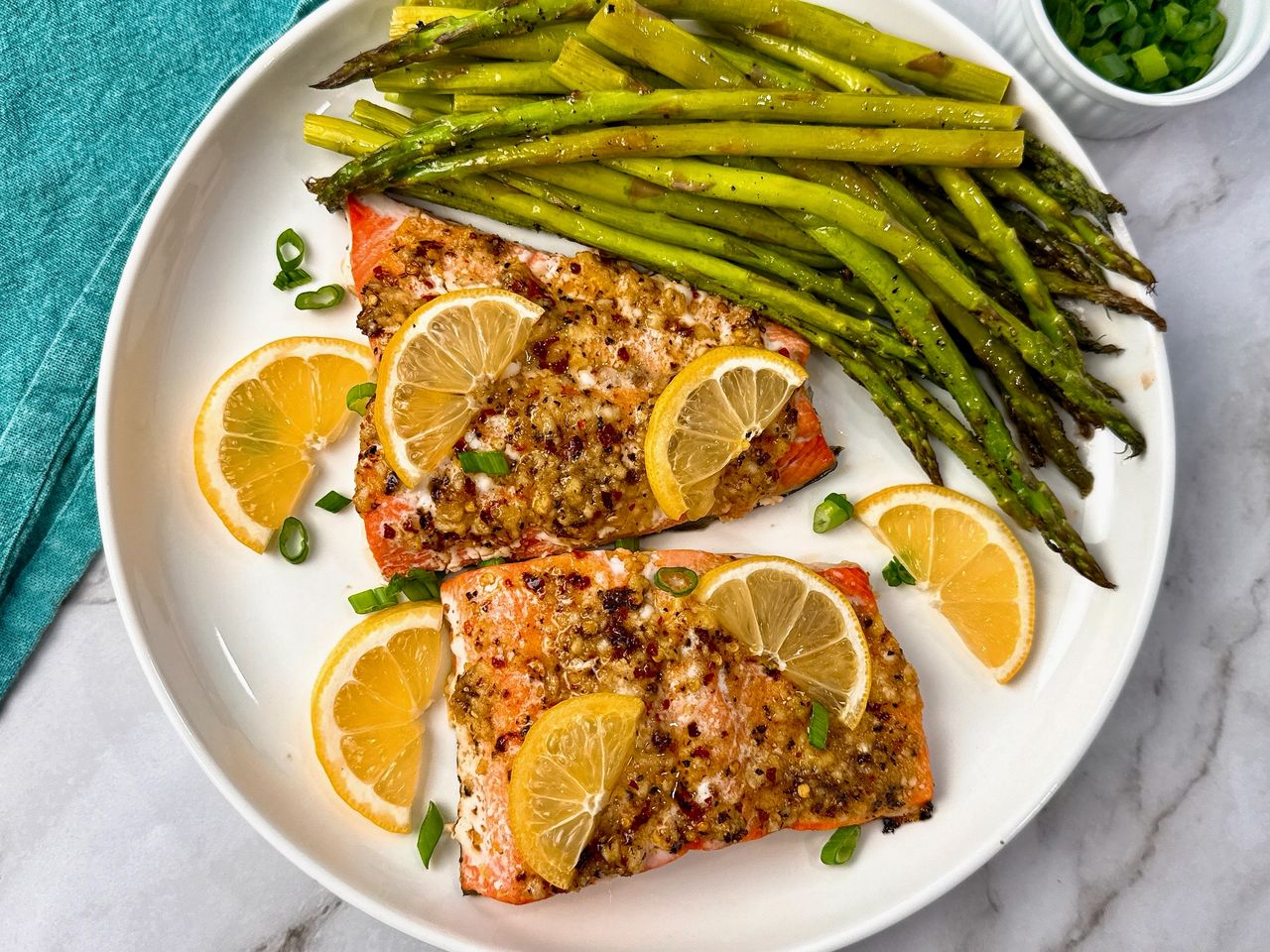 salmon on a white plate with lemon slices