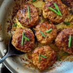 polish sausage on a spoon in a skillet