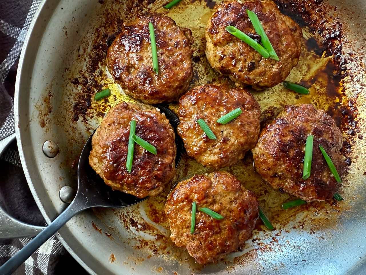 polish sausage on a spoon in a skillet