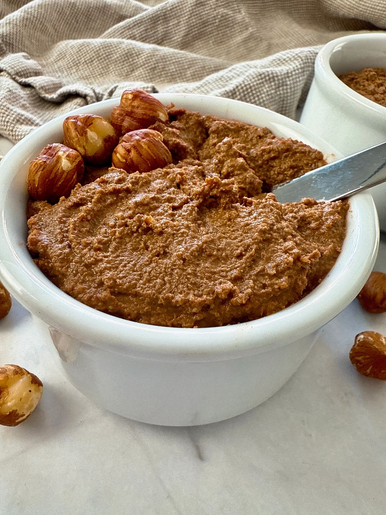 hazelnut spread in a white ramekin with a butter knife