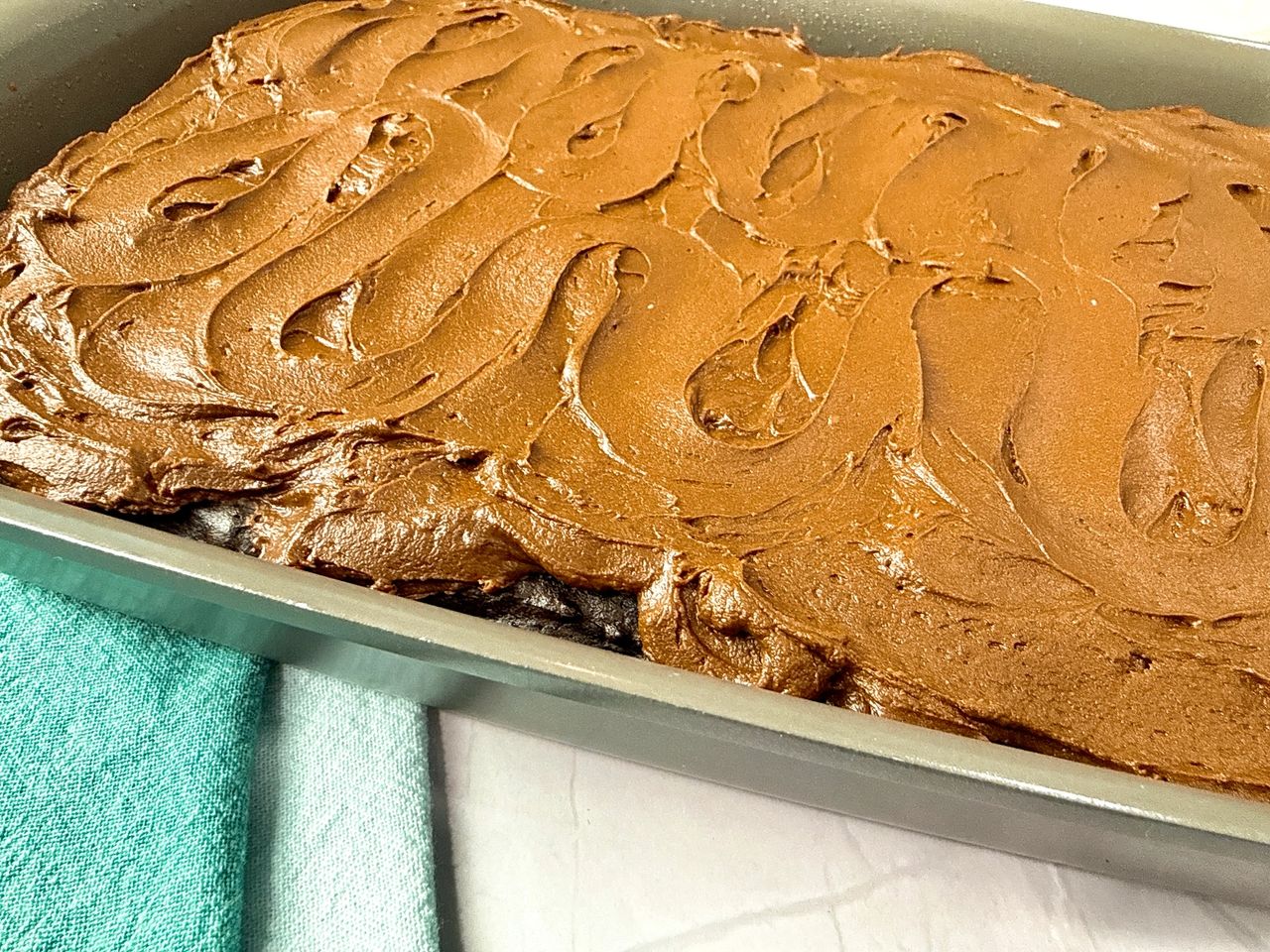 Chocolate Mayonnaise Cake in a cake pan with frosting