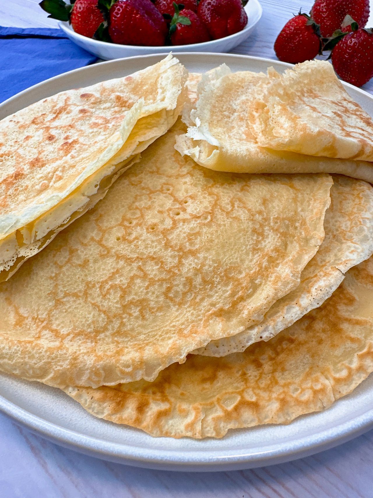 Crepes filled stacked on a plate and served with strawberries