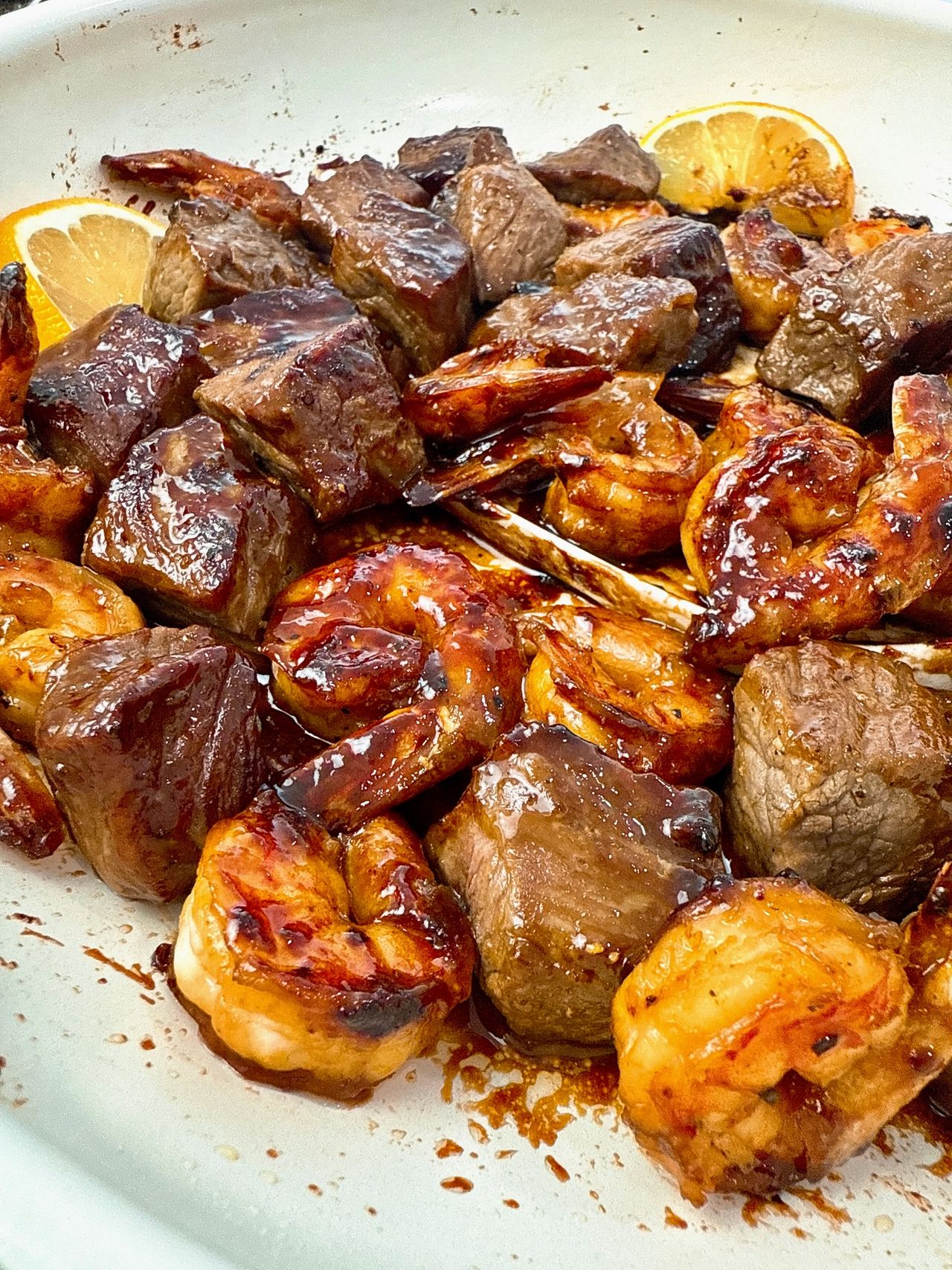 steak and shrimp in a white skillet