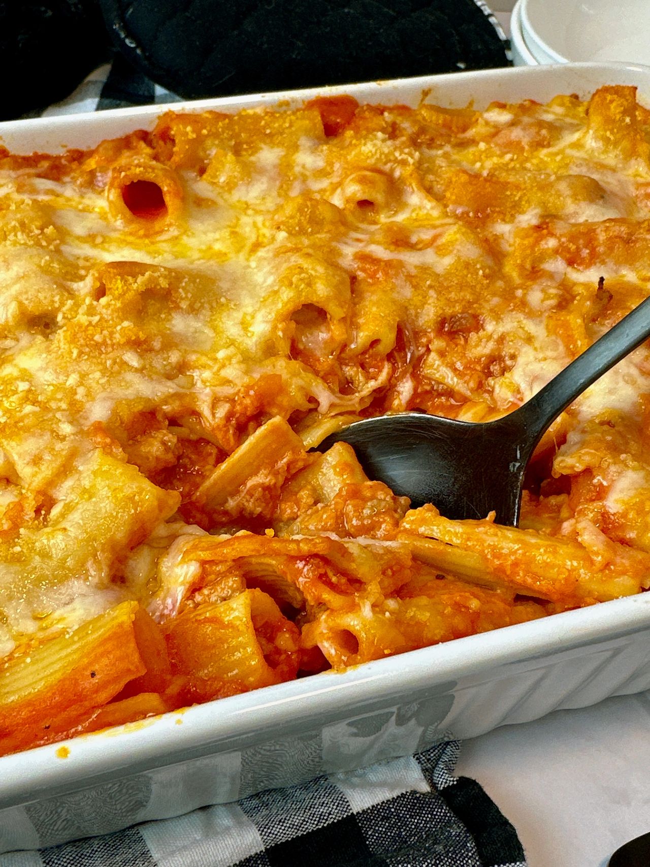 pasta and sausage in a casserole dish and white bowl