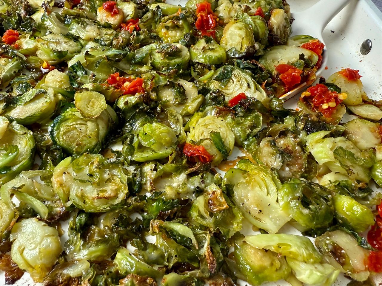 Shaved Brussels Sprouts with Calabrian Peppers on a white baking pan
