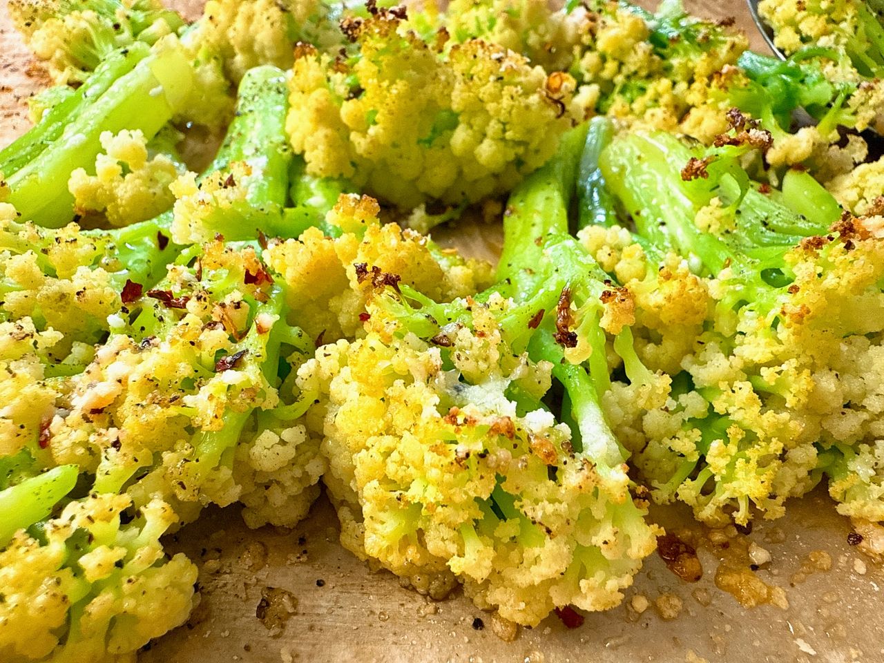 roasted cauliflower with parmesan cheese on a baking sheet
